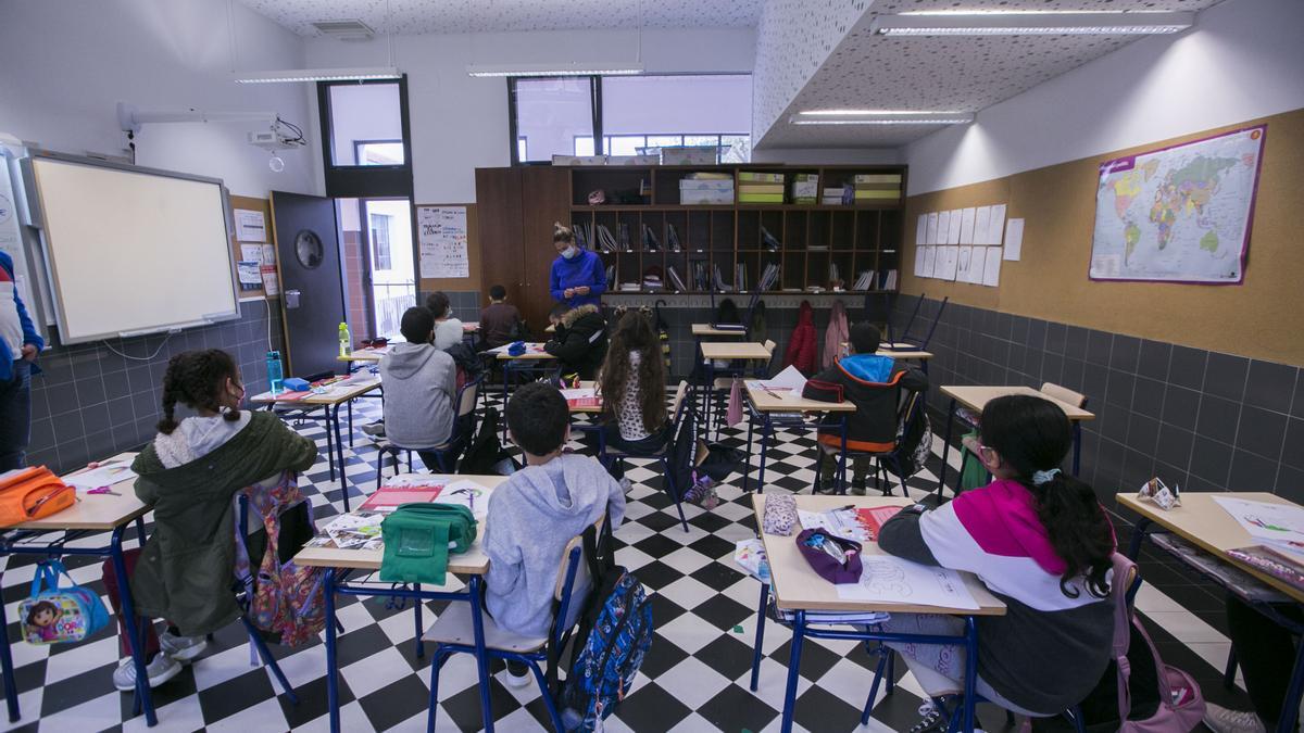 Un grupo de alumnos atiende a la maestra en una aula de Gandia