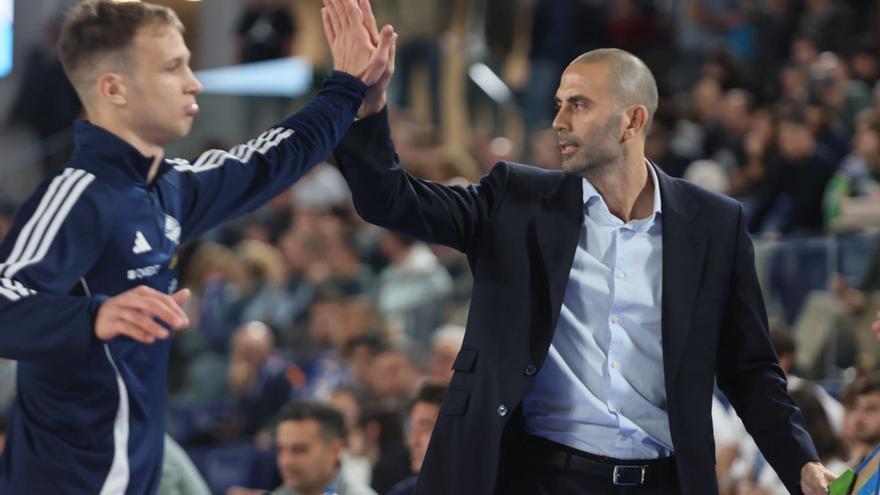 Dan Duscak, a la izquierda, choca la mano con el entrenador del Alimerka Oviedo Javi Rodríguez.  |