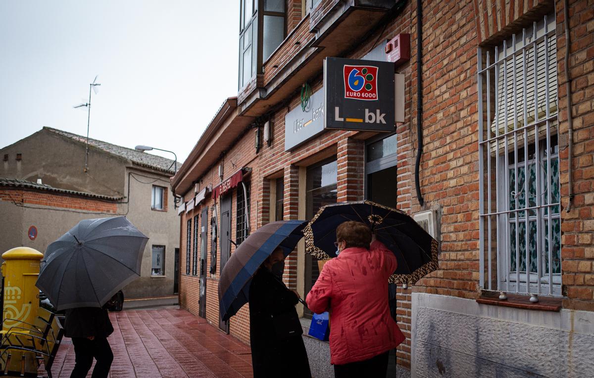 Varias clientas hacen fila en el penúltimo día con la sucursal de Liberbank de Alcabón abierta.