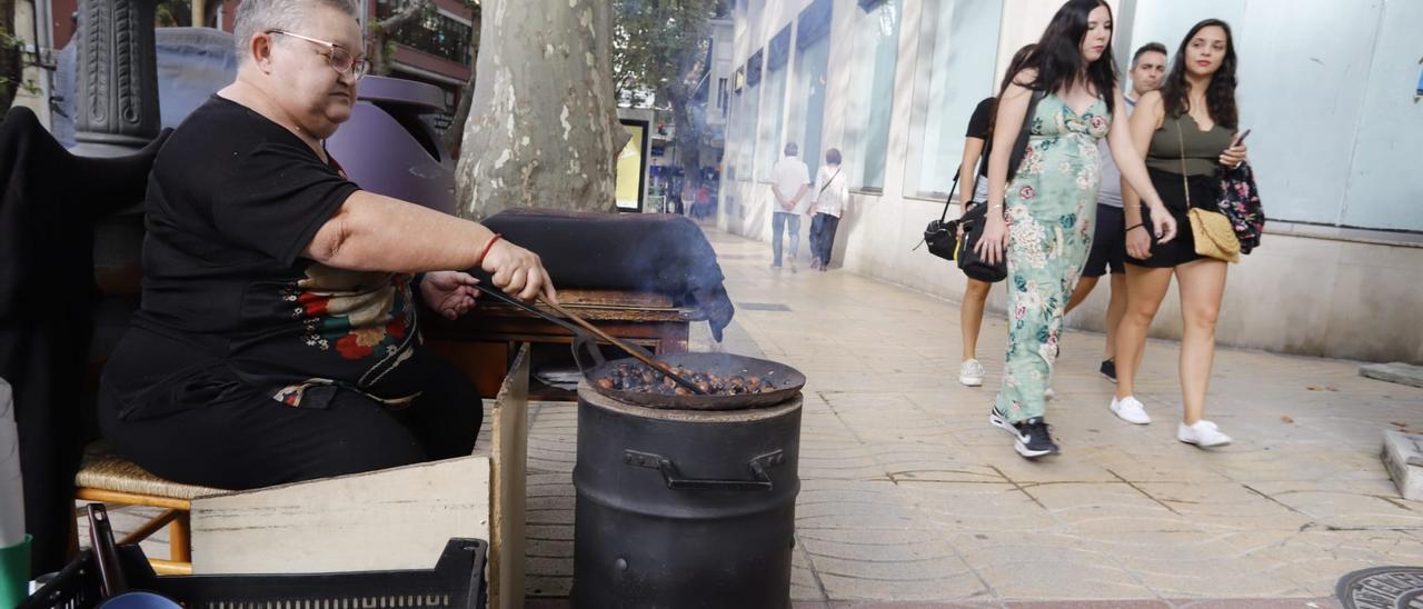 Unas chicas pasan manga corta delante de una castañera en Xàtiva.