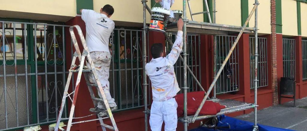 Celestino Mesquita, Francisco Merino y Moisés Bores, alumnos de Fucomi, trabajando en la fachada del colegio de Santa Cruz.