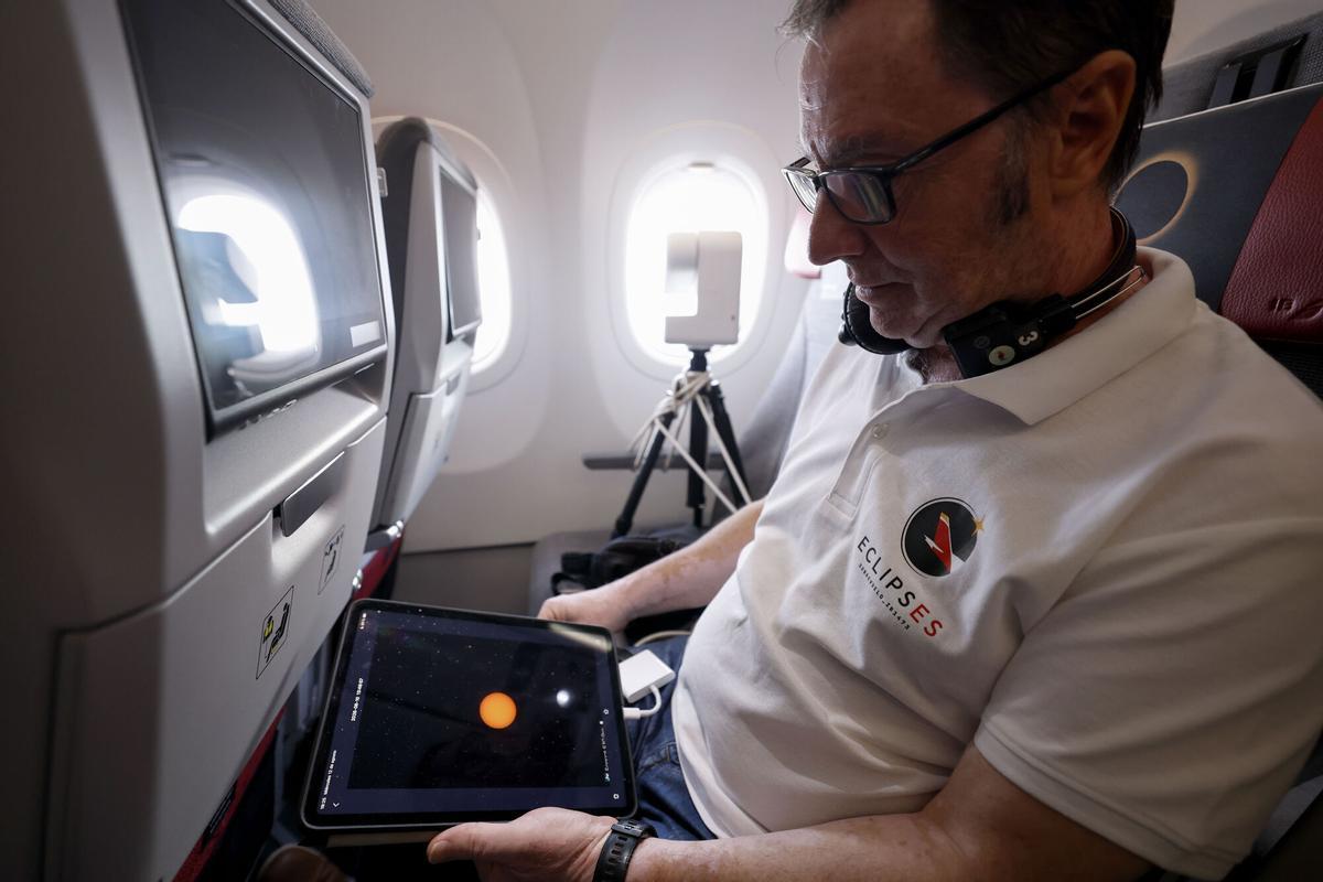 Un hombre efectúa seguimiento del eclipse en un avión. Un hombre efectúa seguimiento del eclipse en un avión.