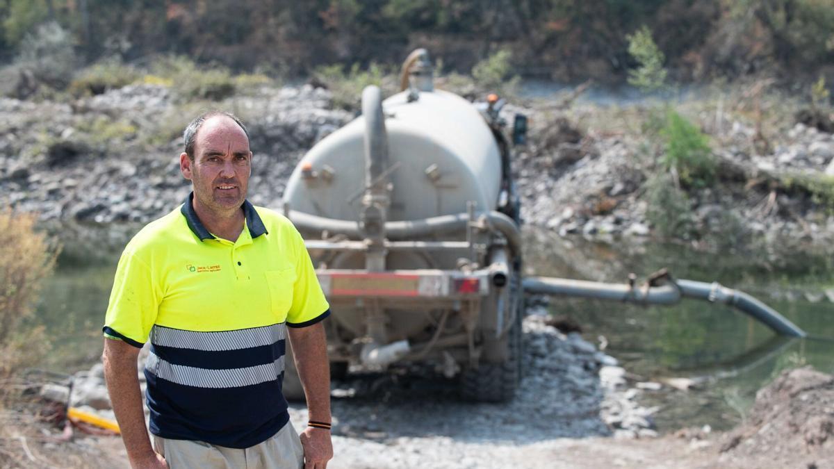 Alejandro Jaca, junto al río Aragón, mientras la cuba de su tractor se llena.