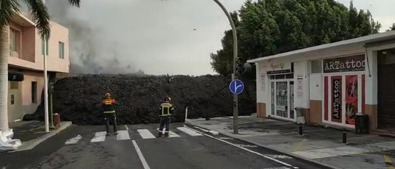 Bomberos ante el avance de la lava del volcán en las proximidades de la iglesia de La Laguna