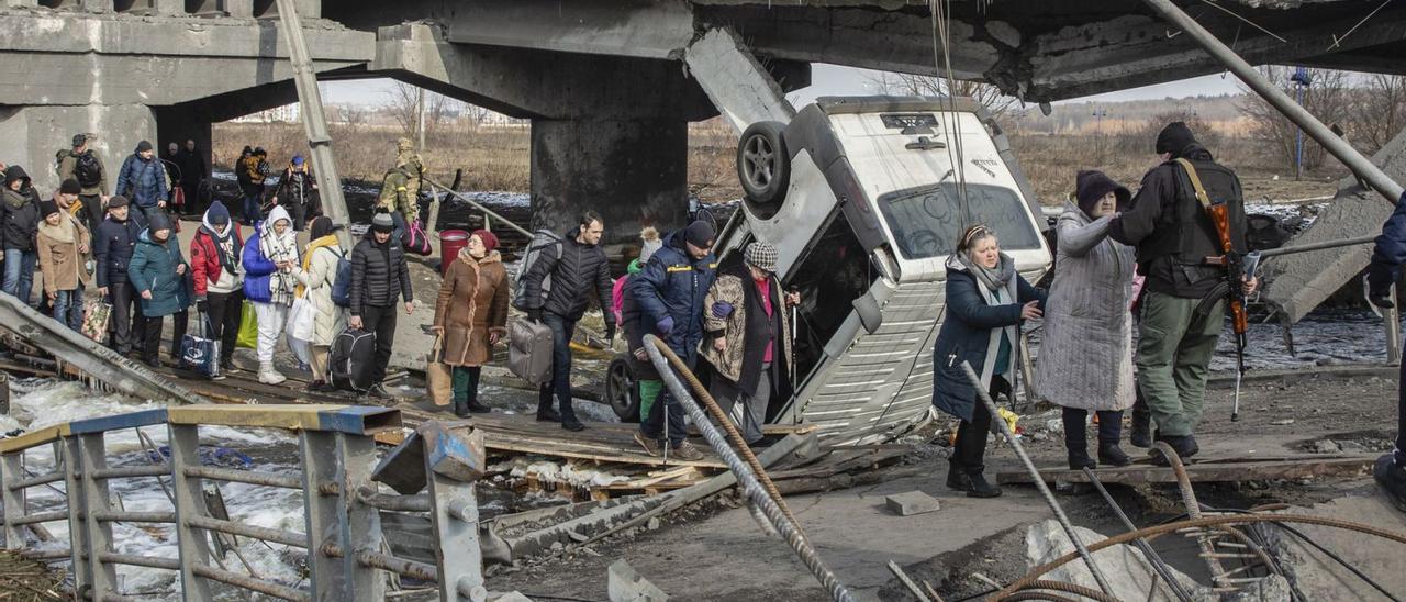 Un grupo de gente huye de la ciudad de Irpin (Ucrania) a través un de un puente destruido por los bombardeos.  | | EFE/MIKHAIL PALINCHAK