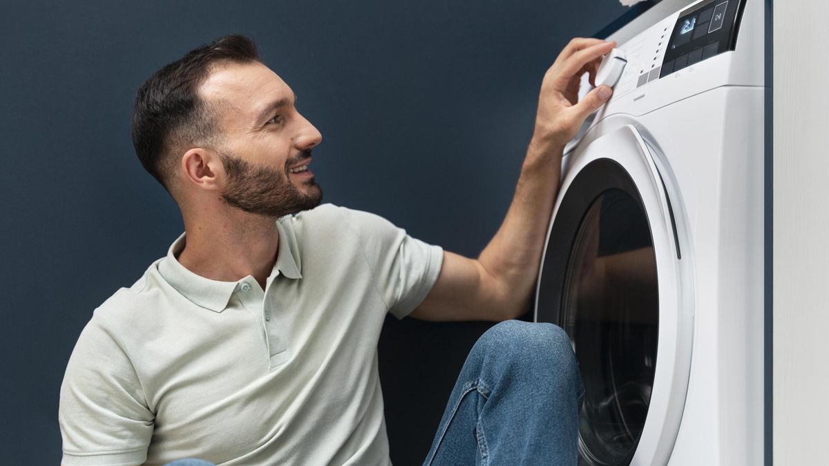 Hombre esperando que lavadora termine su programa