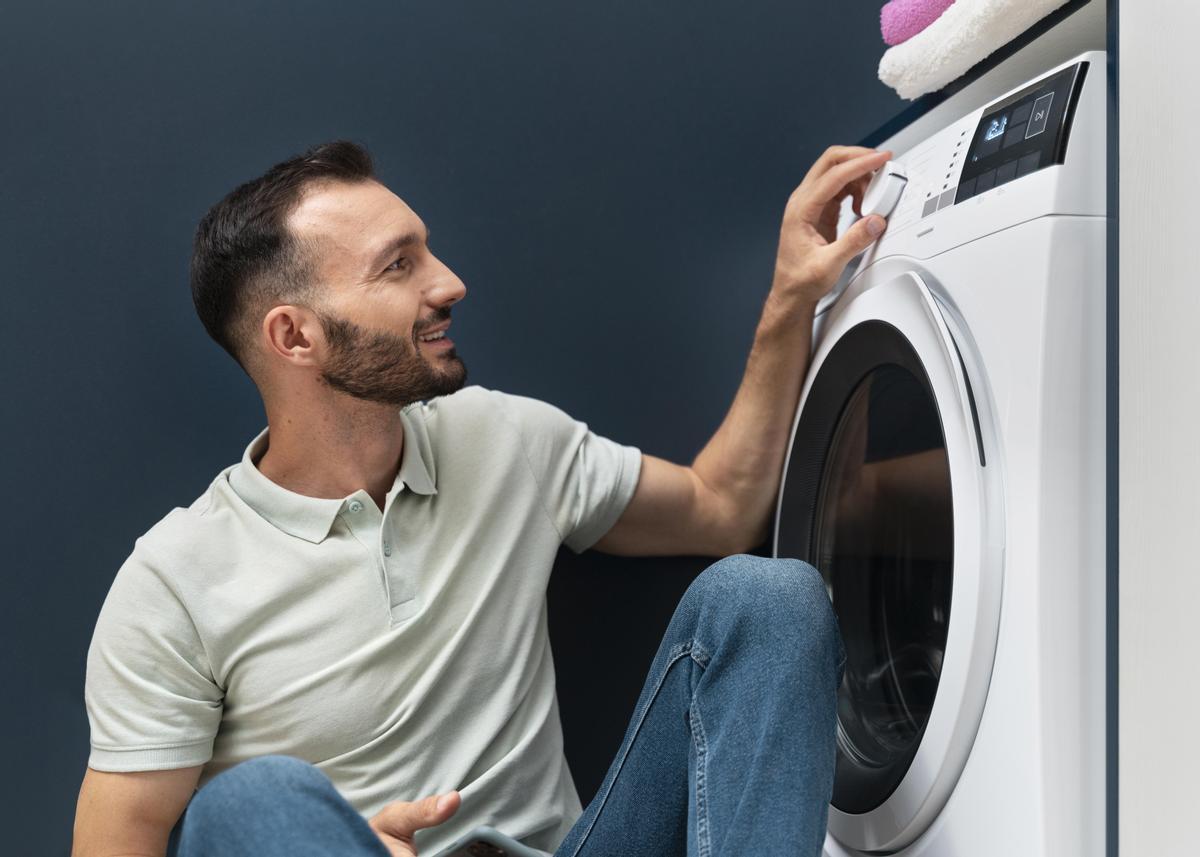 Hombre esperando que lavadora termine su programa