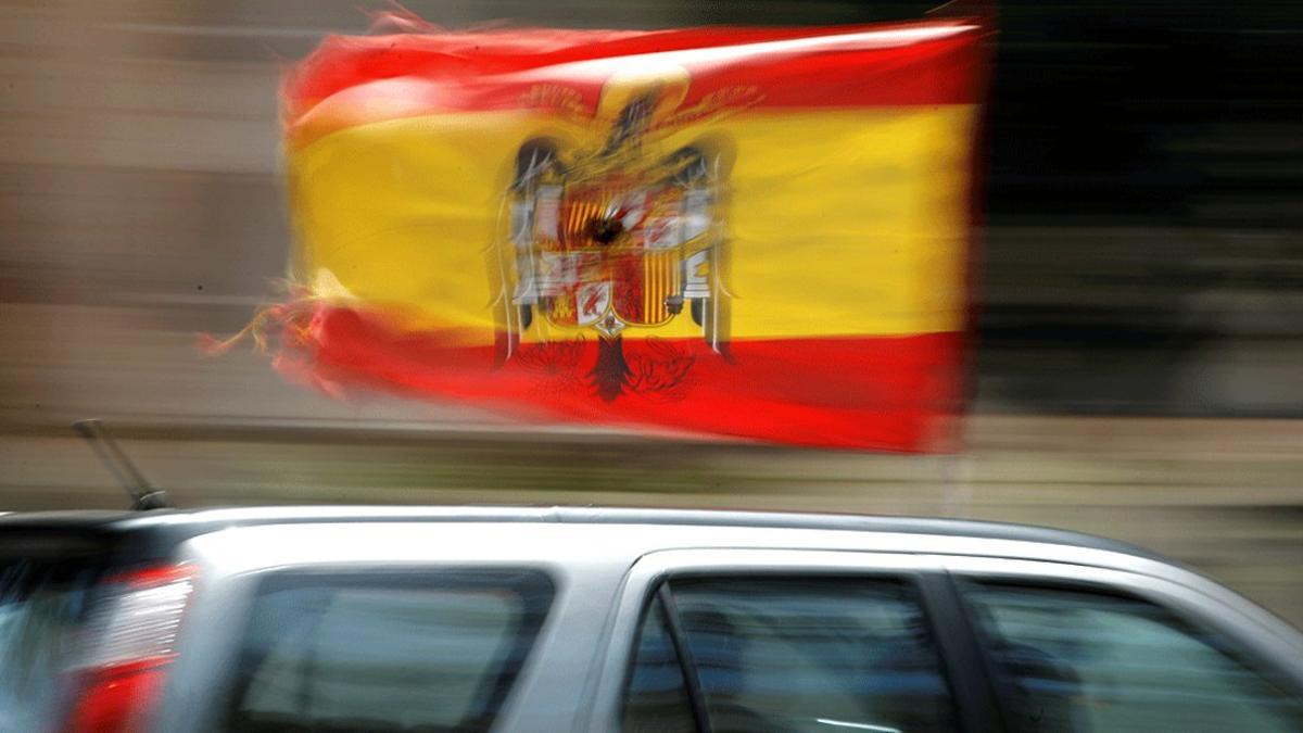 Un coche pasea la bandera preconstitucional durante la manifestación convocada por Vox contra el Gobierno, el 23 de mayo en Málaga