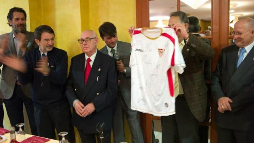El vicepresidente de San Crispín, José Luis Jiménez, muestra una camiseta del Sevilla junto a Víctor  Ferreras.