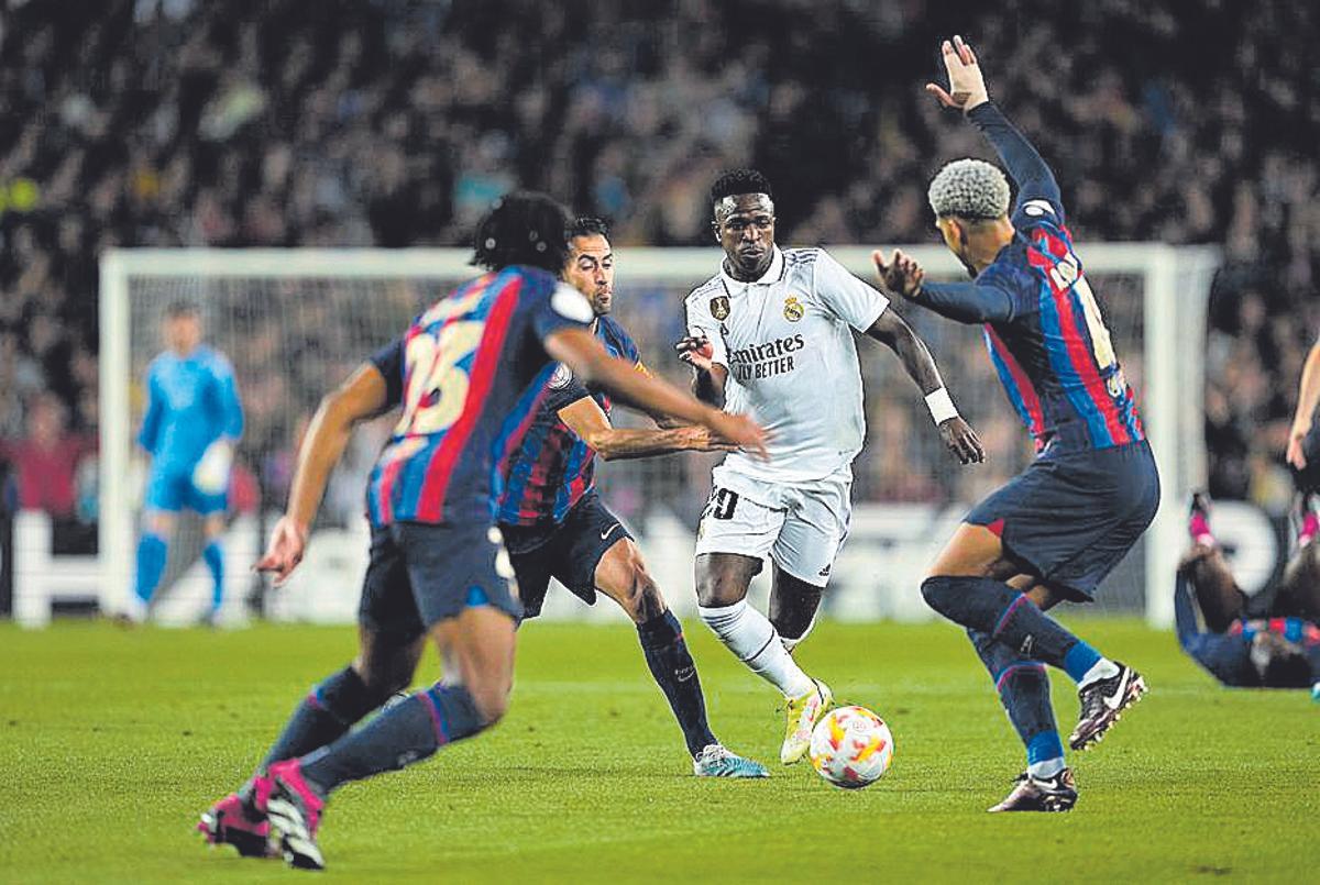 Vinicius, entre Busquets, Araújo i Koundé en el partit de Copa que els blancs van guanyar per 0-4 al Camp Nou