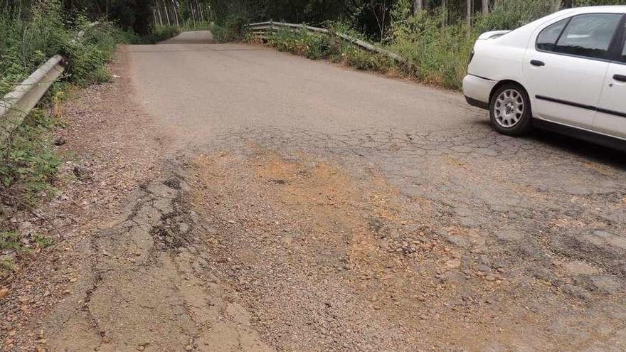 Un coche circula por la orilla de la calzada entre Manganeses y Villabrázaro para evitar un bache