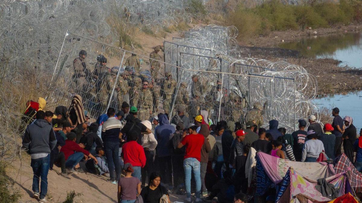 Migrantes acampan a lo largo de la orilla del río Grande mientras esperan entregarse a las autoridades de inmigración en El Paso, Texas, EE.UU