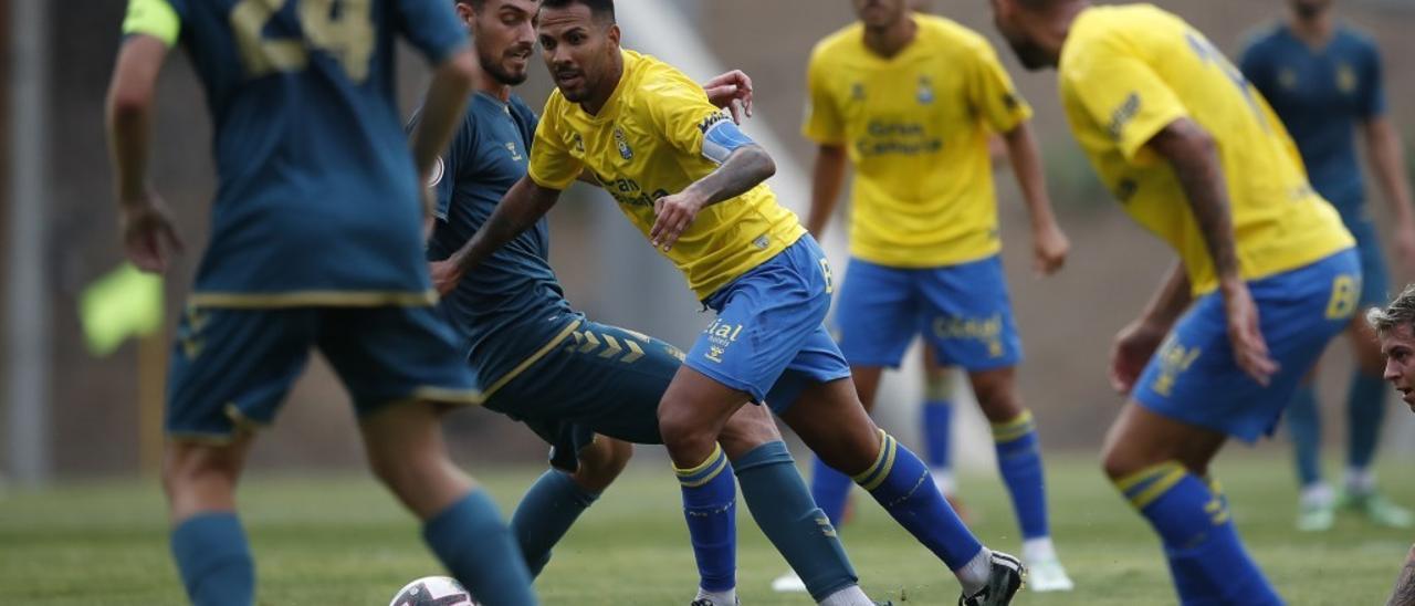 Jonathan Viera se marcha de un rival de Las Palmas Atlético ante Benito y Fabio.