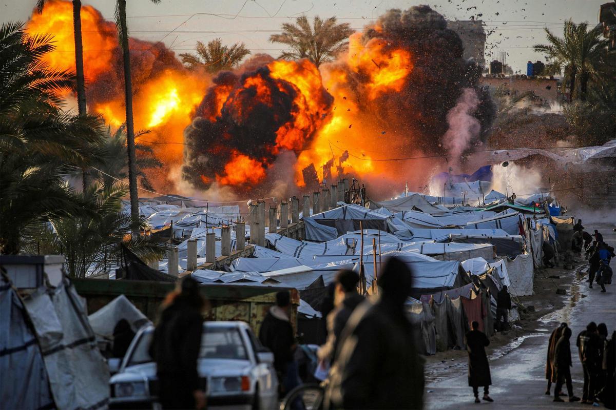 Una bola de fuego estalla después de un ataque israelí cerca de un campamento de tiendas de campaña que alberga a personas desplazadas por la guerra en Deir el-Balah en el centro de la Franja de Gaza el 25 de marzo de 2026.