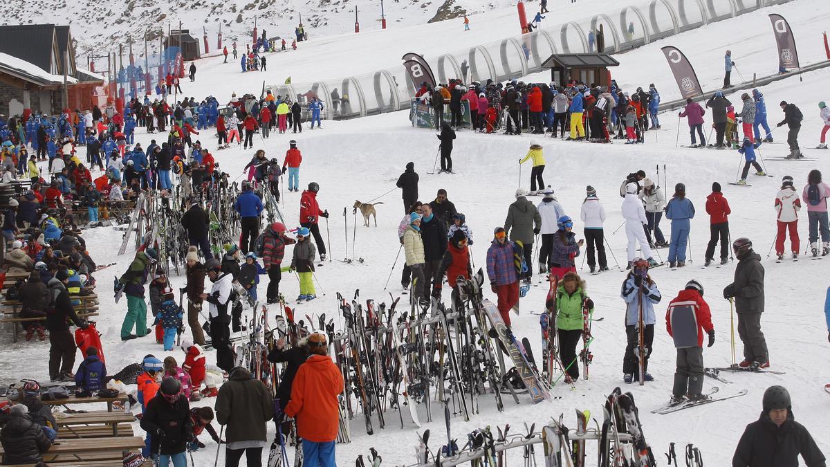 Decenas de esquiadores hacen fila para subir a los remontes de la estación de esquí de Formigal mientras otros aprovechan para descansar tras una jornada de deporte.