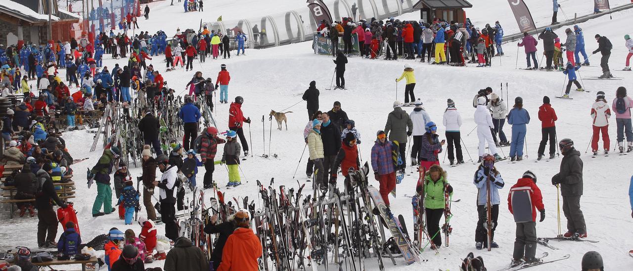 Decenas de esquiadores hacen fila para subir a los remontes de la estación de esquí de Formigal mientras otros aprovechan para descansar tras una jornada de deporte.