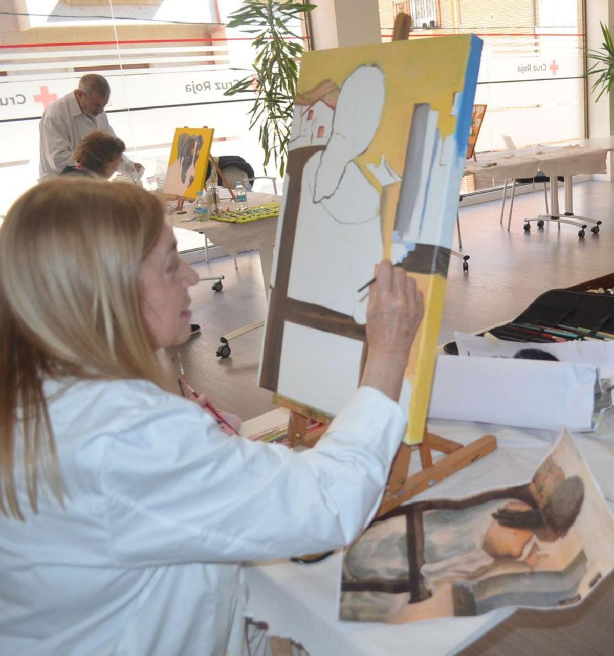 El taller de pintura se realiza en una de las salas de la sede de Cruz Roja en Benavente. | E. P.