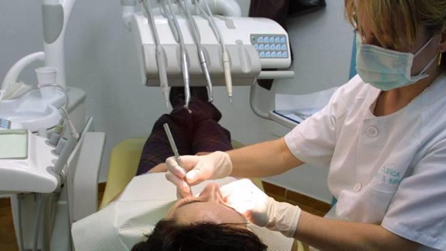 Una odontóloga atiende a un paciente para realizarle un tratamiento en su clínica.