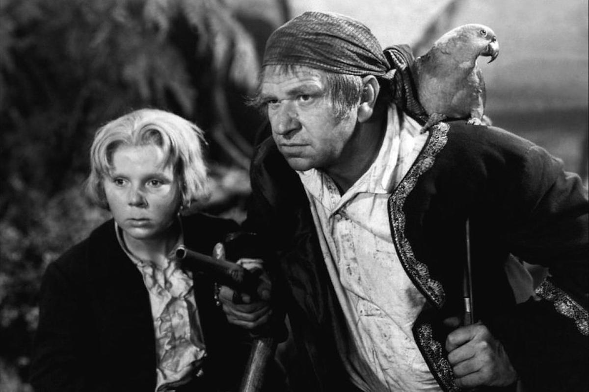 Fotograma de la película "La isla del tesoro" (1934), de Victor Fleming, con Jackie Cooper y Wallace Beery en los roles de Jim Hawkins y Long John Silver.