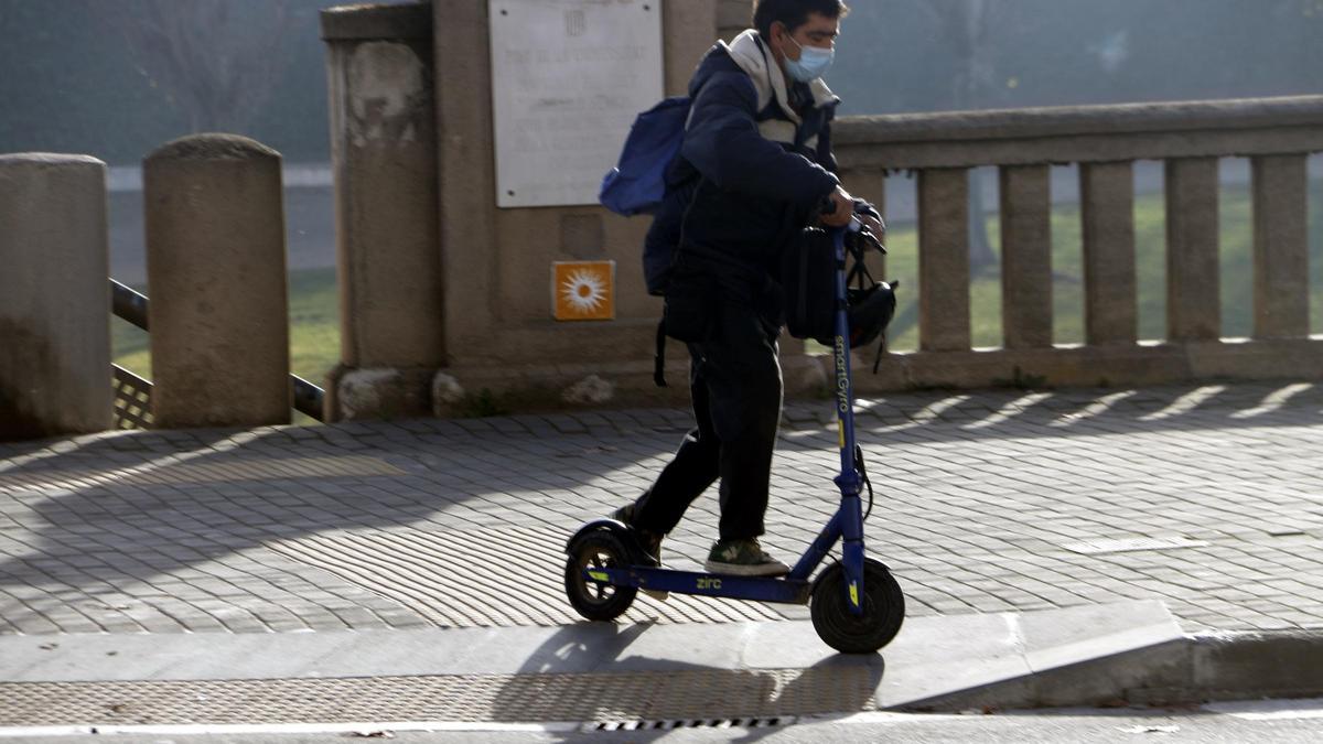 Pla obert d&#039;un noi en patinet per l&#039;avinguda del Segre, sense casc. Imatge del 28 de desembre de 2021.