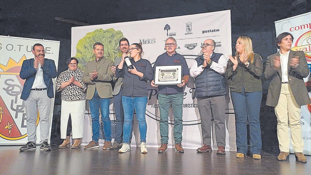 Román Gutiérrez, en el centro, con el diploma que la acredita como el cocinero del mejor pote en las dos últimas ediciones del concurso de Turón