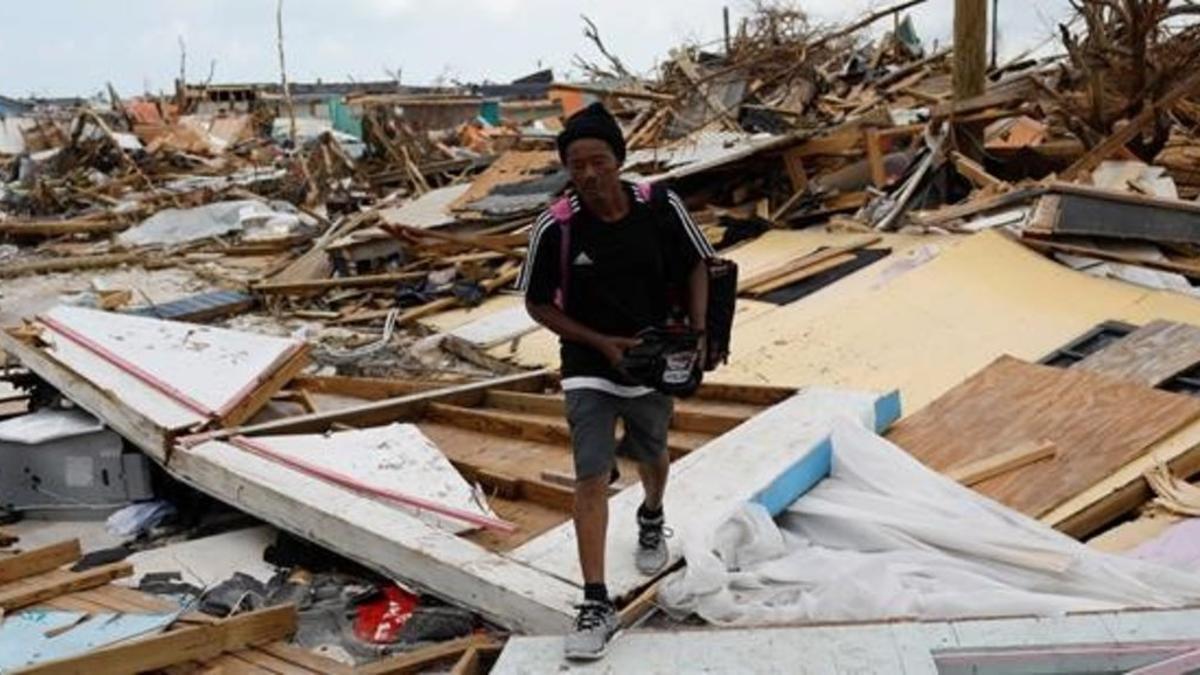 Un hombre camina por un vecindario devastado por el huracán 'Dorian' en las islas Abaco.