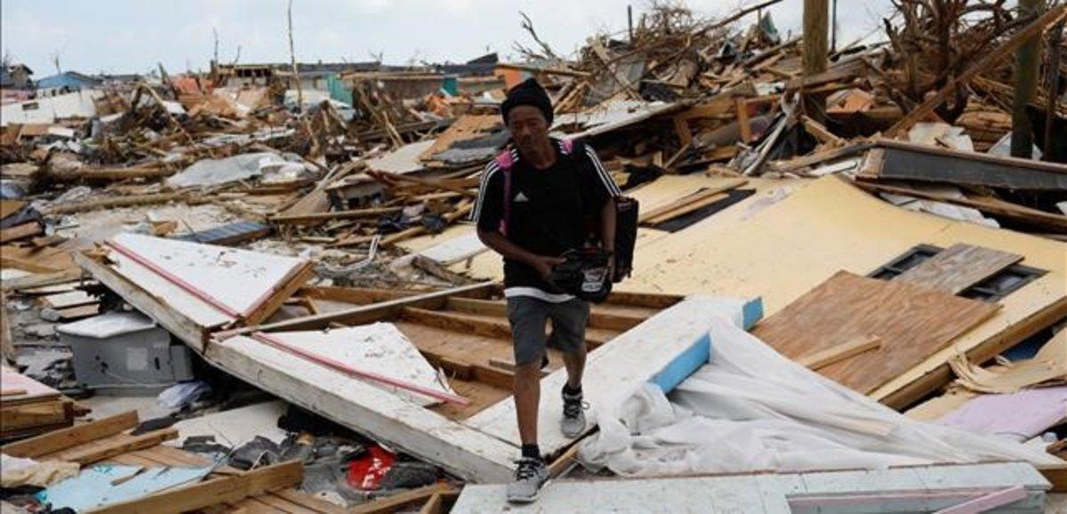 undefined49733119 a man walks among debris at the mudd neighborhood  devastate190906183044