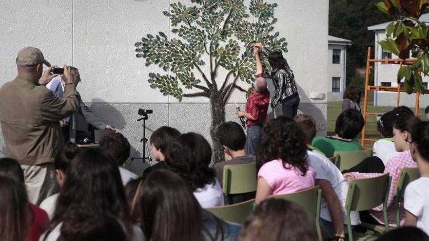 El artesano y los alumnos, ayer, en la colocación de las hojas del mural en el instituto.