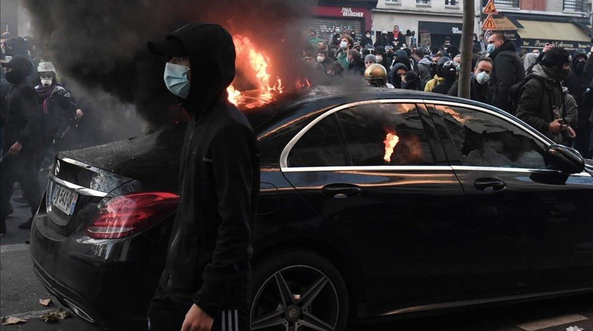 zentauroepp56030765 a protester walks past a burning car during a protest agains201129155749