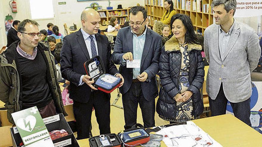 Profesores y autoridades muestran el equipo desfibrilador ante los alumnos de 5º del CEIP Mestre Vide. // Brais Lorenzo