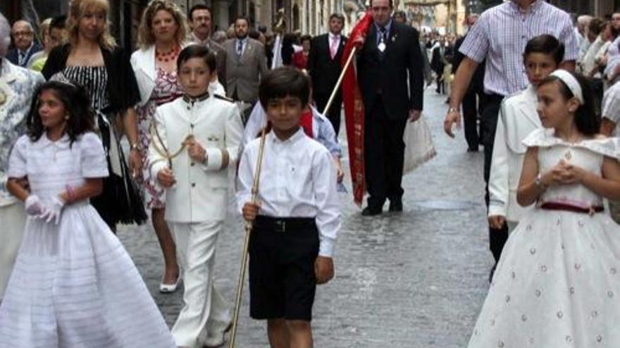 Jorge Pérez, junto a cuatro niños y niñas de Comunión, ayer en la procesión del Corpus de Alcoy.
