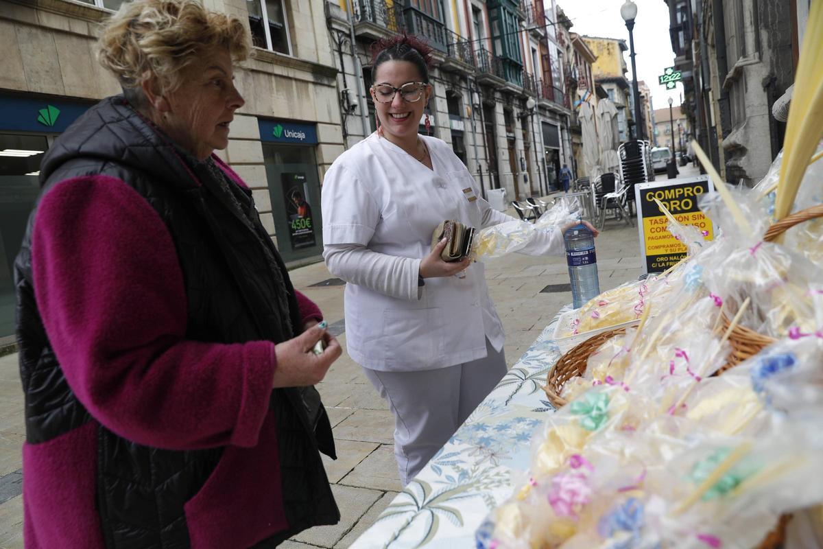 Mari Luz González Álvarez  vendiendo una palma en Avilés a Ángela Crespo.