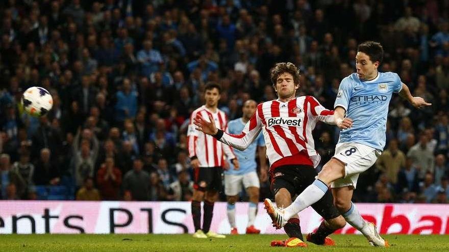 Nasri, del Manchester City, golpea el balón ante un defensa del Sunderland. // Darren Staples