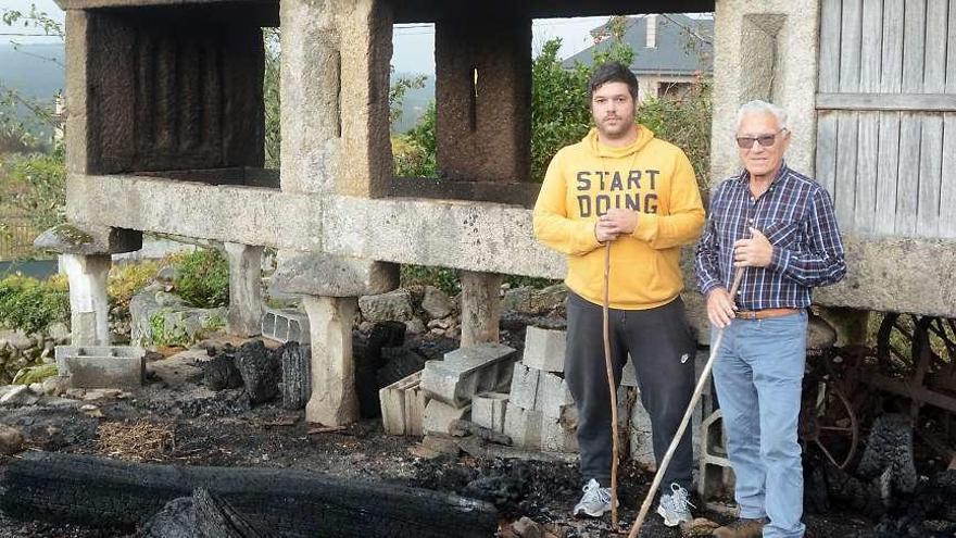 José Lorenzo Hermida con su hijo junto a su hórreo quemado. // R.V.