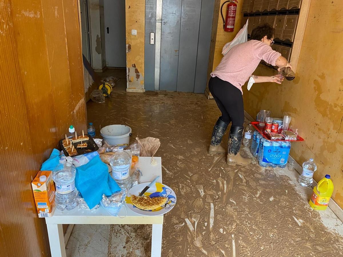 Una vecina prepara un café a otro vecino que está trabajando en la calle. A la izquierda, su tortilla de cebolla.