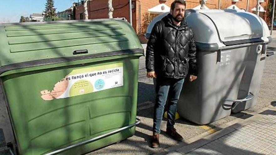 Serracanta entre dos contenidors, un de vell, verd, i el nou, de color gris