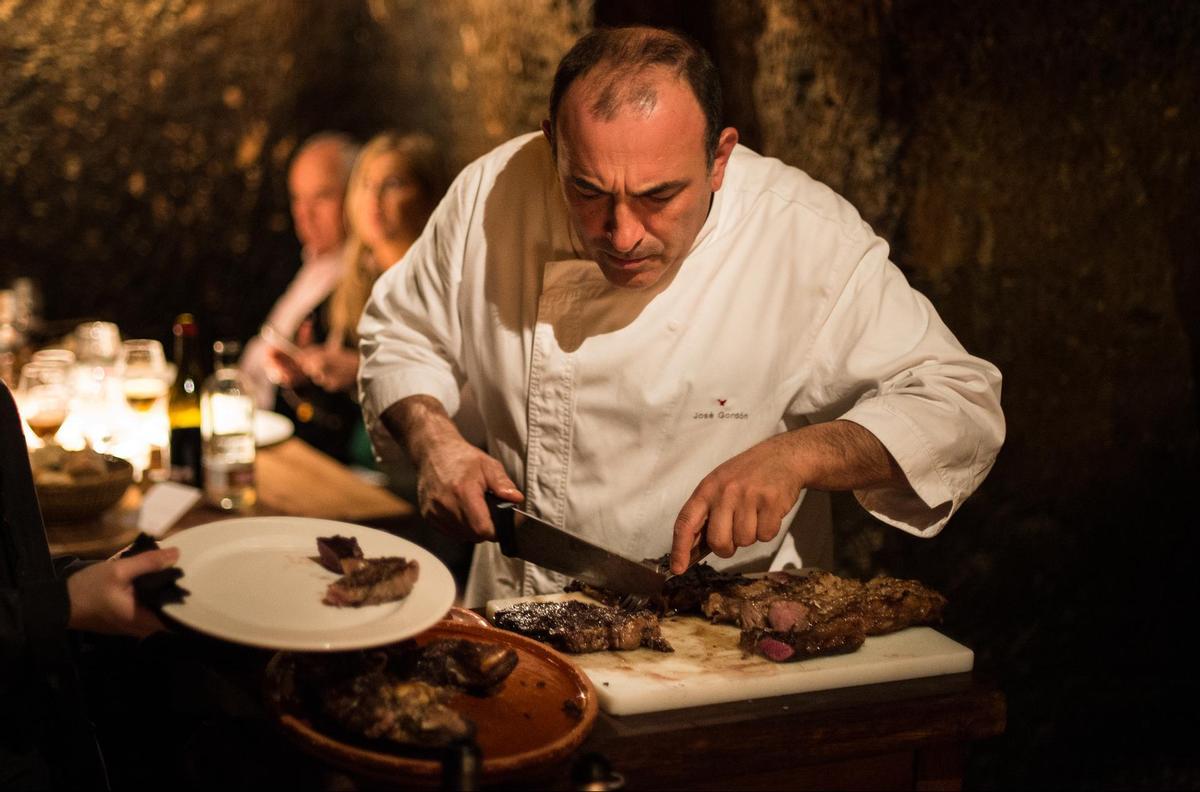 El chef y dueño de El Capricho realiza un corte a una de las chuletas de buey preparadas en su restaurtante.