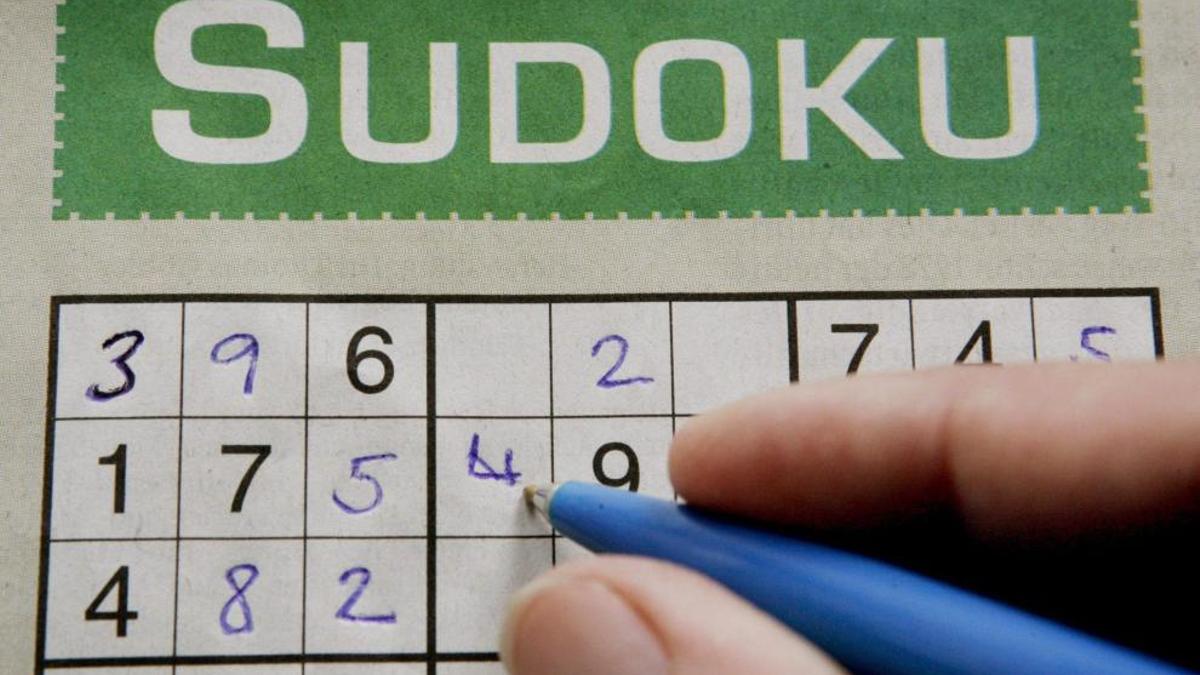 Una mujer rellena los cuadros en blanco de un Sudoku.