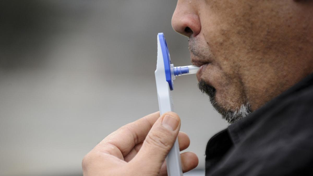 Un conductor realiza una prueba de alcoholemia.