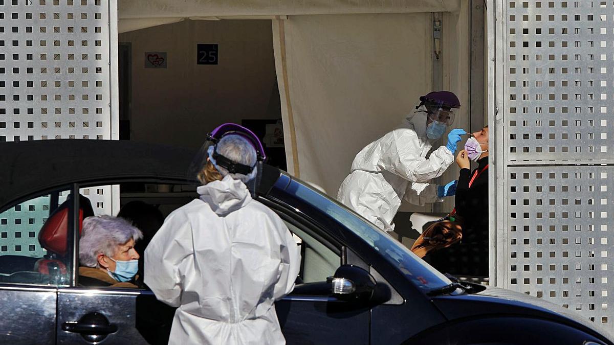 Dos sanitarios realizan pruebas PCR a pacientes en coches y en el hospital de campaña de La Fe. | M. A. MONTESINOS