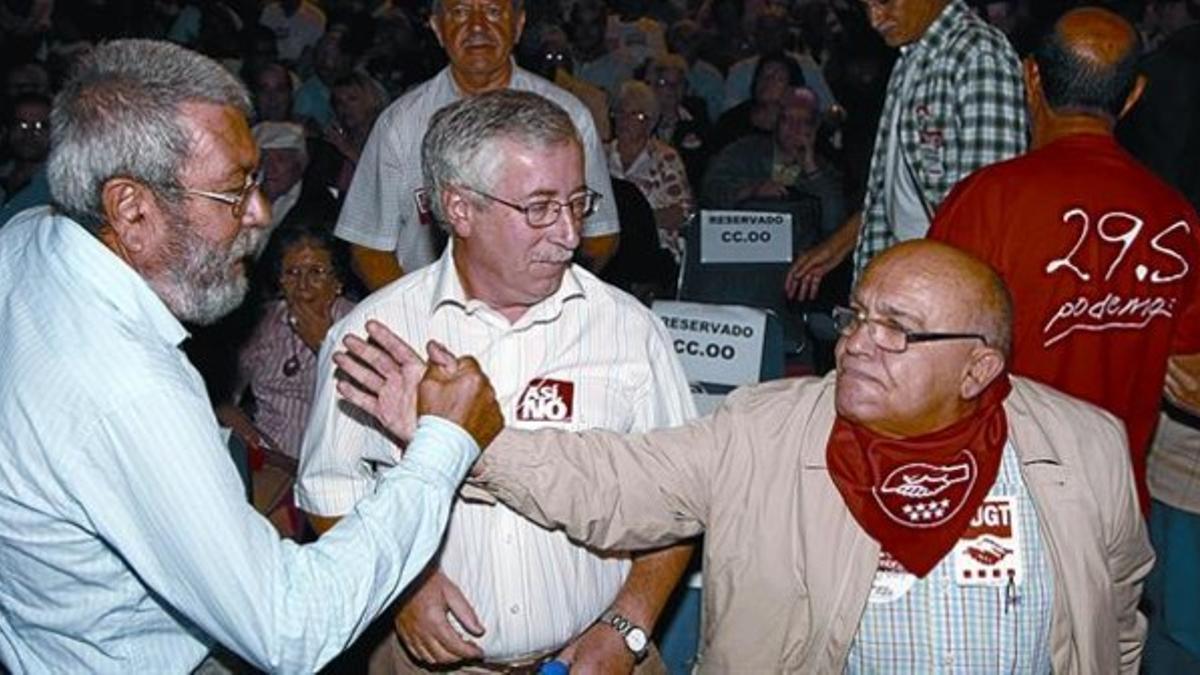 Méndez (izquierda) saluda a un jubilado frente a Toxo en una asamblea celebrada ayer en Madrid.