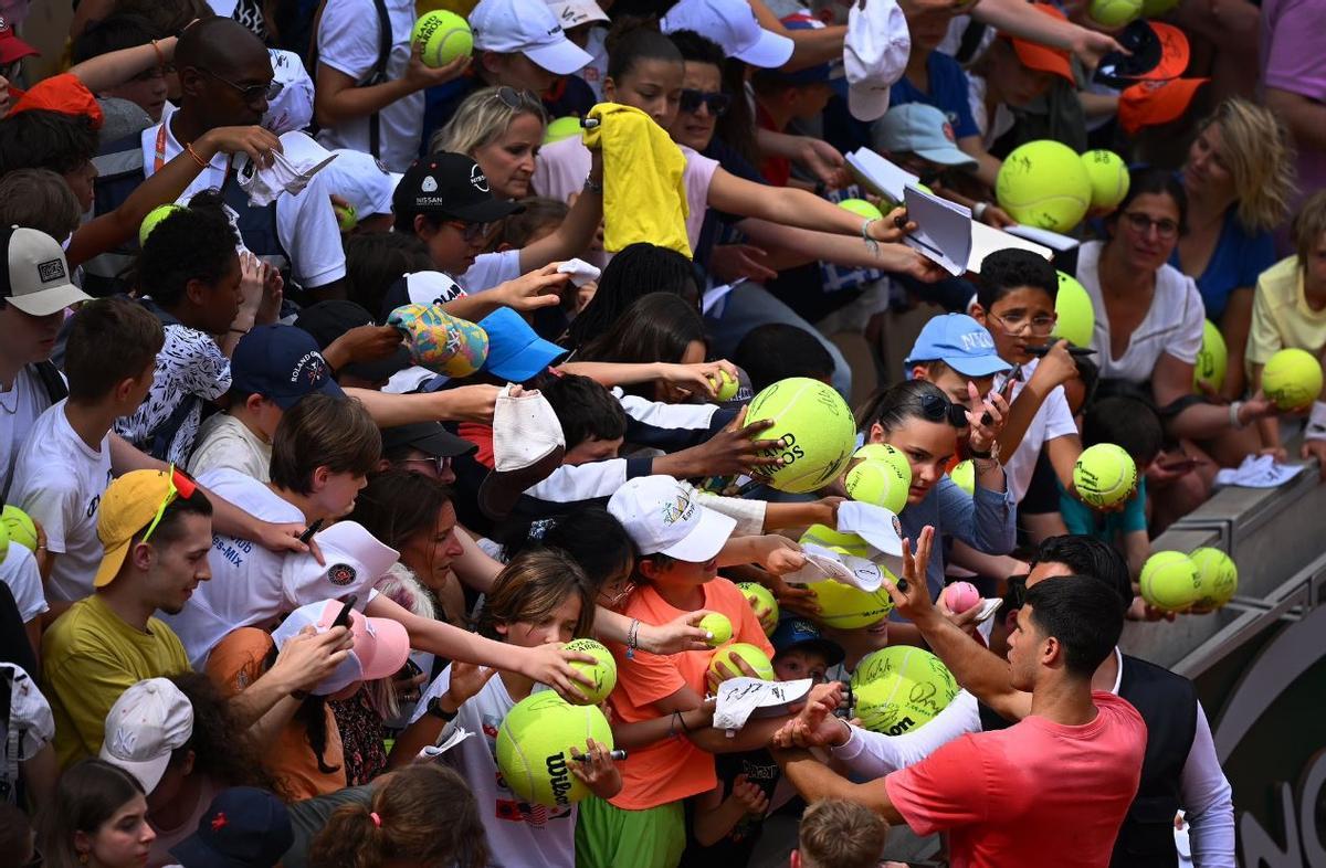 Carlos Alcaraz firma autógrafos a los aficionados en Roland Garros.