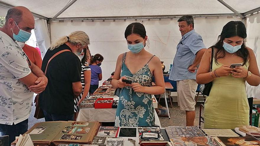 Vecinos admiran antiguos libros y cómics en un stand. | M. J. C.