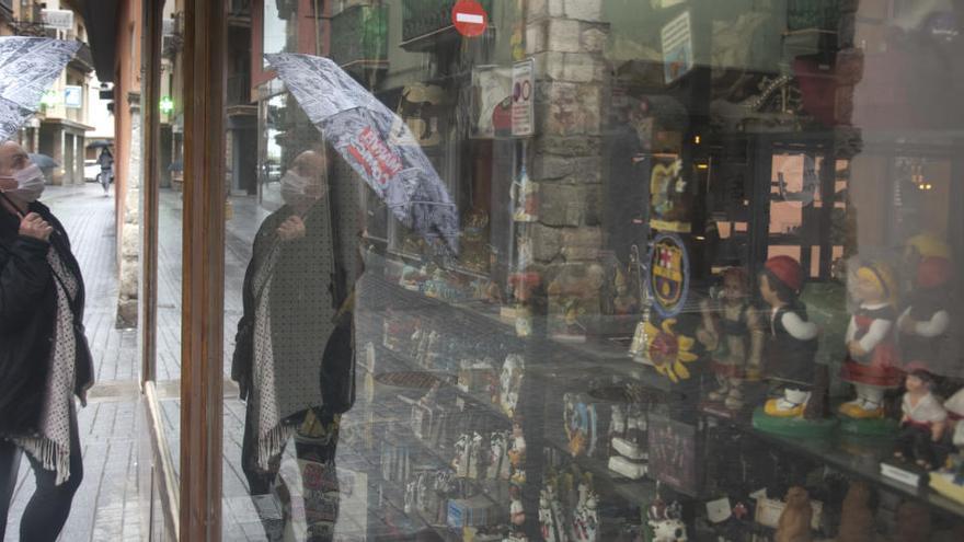 Una dona mira l&#039;aparador d&#039;una botiga tancada al centre de Puigcerdà |