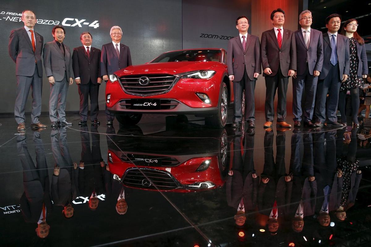 Executives are pictured next to a newly unveiled Mazda CX-4 during the Auto China 2016 auto show in Beijing April 25, 2016. REUTERS/Damir Sagolj