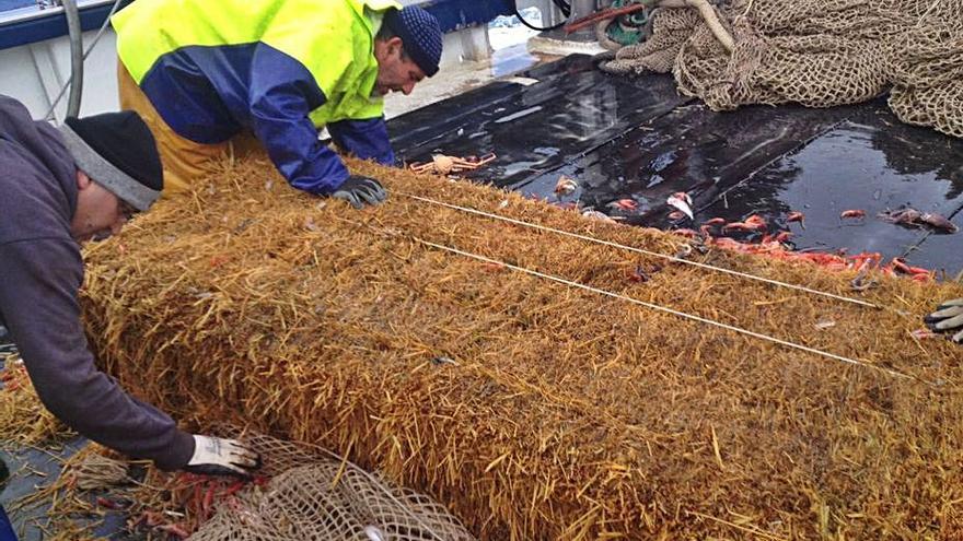 Dos pescadores, tras capturar una bala de gran tamaño.