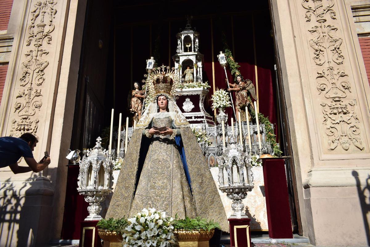 Un hombre hace una foto a la virgen frente al altar culminado el día previo al Corpus