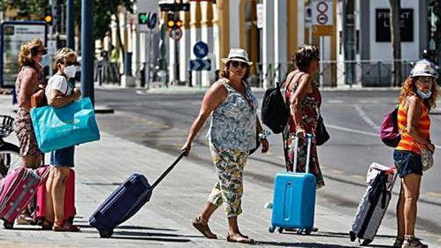 Turistas arrastran sus maletas en el puerto de Ibiza, este verano.