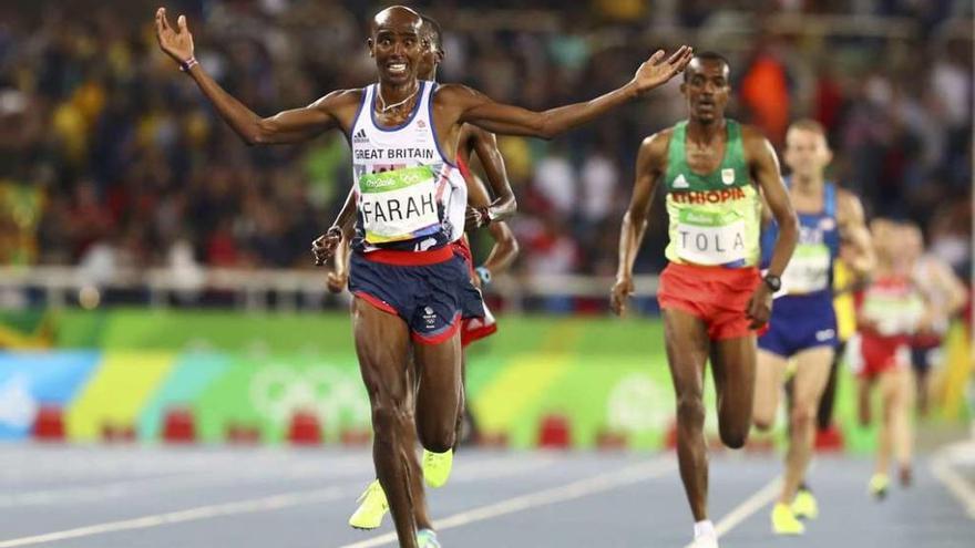 Mo Farah abre los brazos sobre la línea de meta para celebrar su victoria.