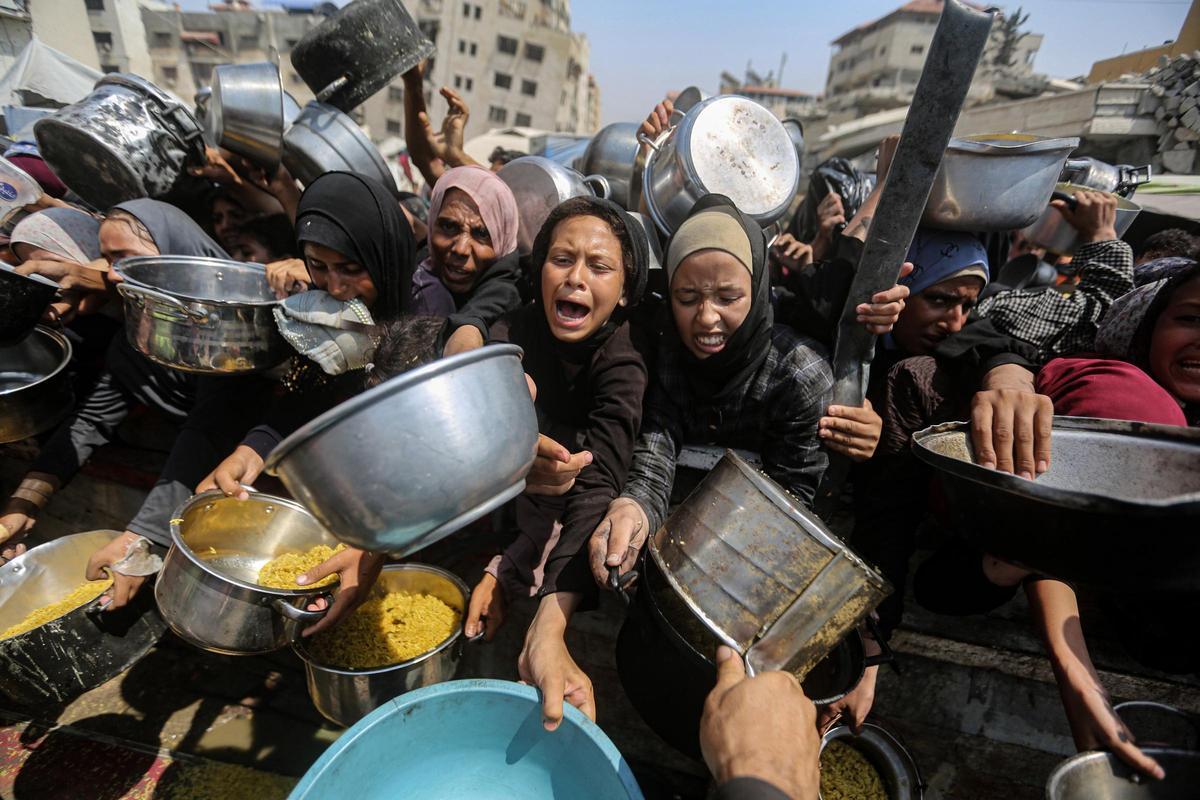 Imagen de archivo de desplazados en Gaza esperando para recibir alimentos.
